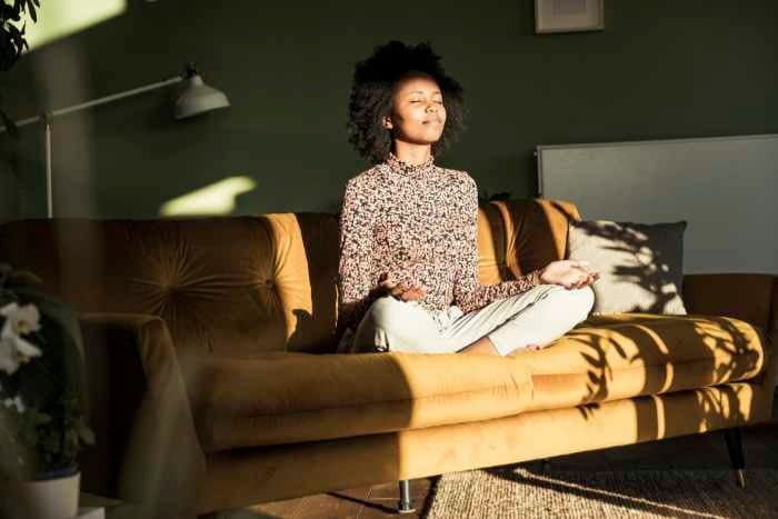 mujer meditando en el sofá