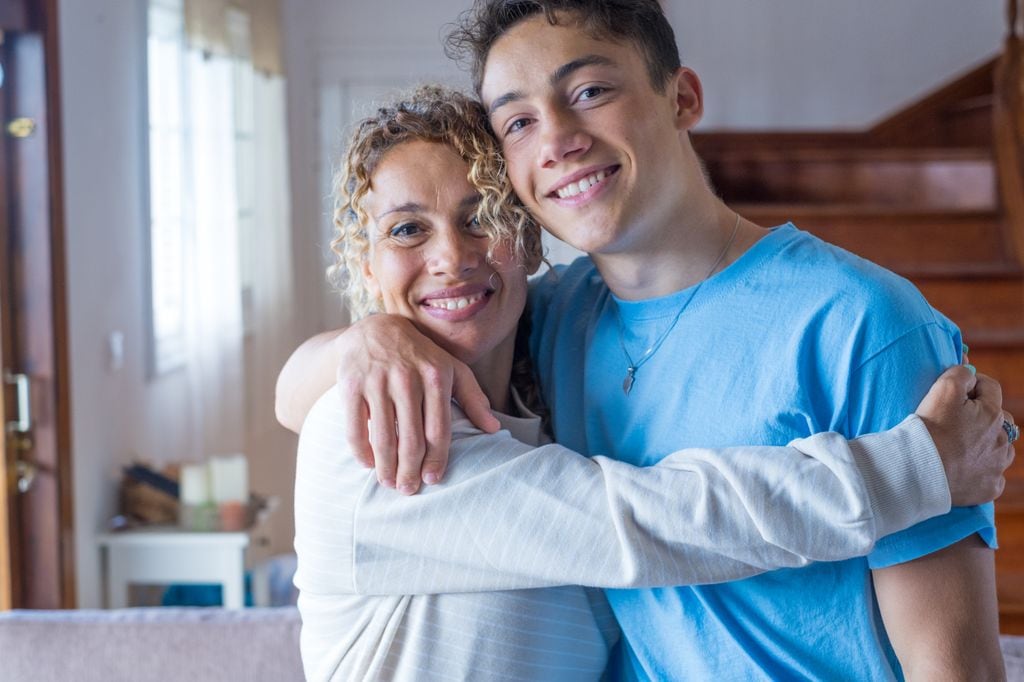 Madre abrazando a su hijo adolescente