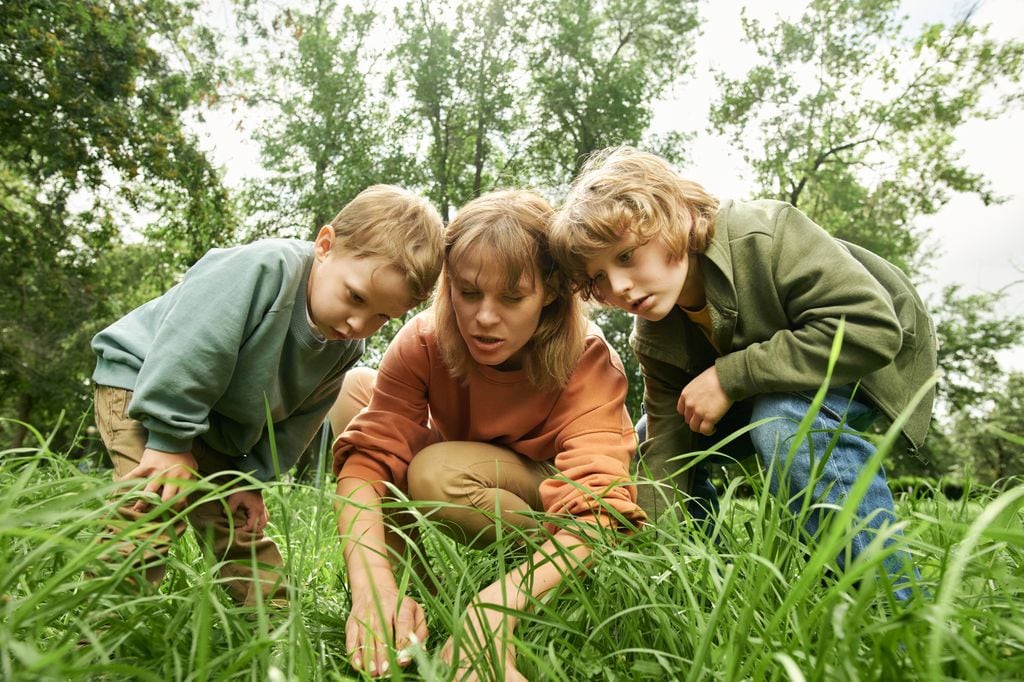 Madre con sus hijos observando en el campo con asombro