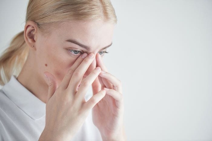 mujer tocándose los ojos