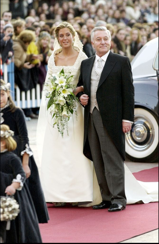 La novia lucía un vestido de raso color blanco vela con escote cuadrado y bordado, al igual que las mangas, y detalles inspirados en el prerrománico asturiano, acompañado de velo de tul acabado en encaje y prendido con un elegante moño bajo