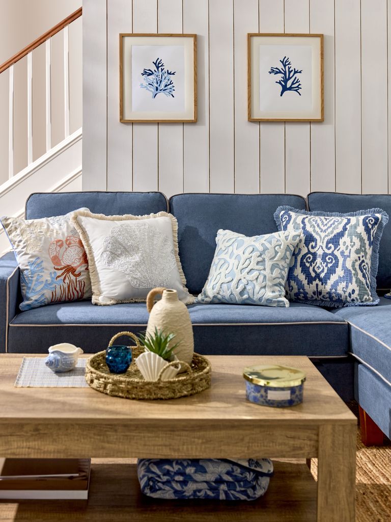 Sofá azul decorado con cojines blancos y azules