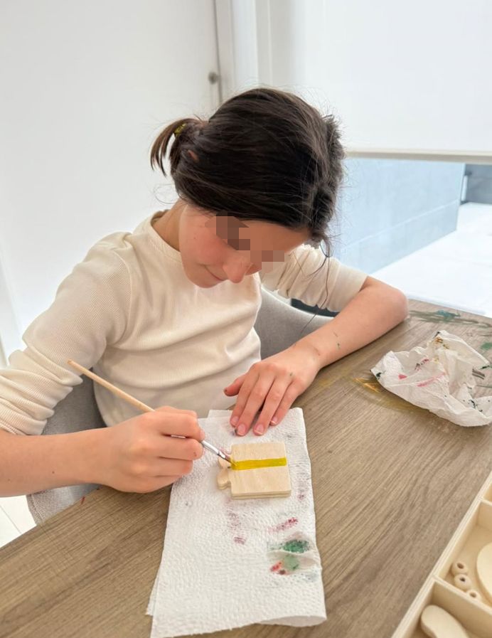 La hija mayor del deportista, moldeando y pintando una figura