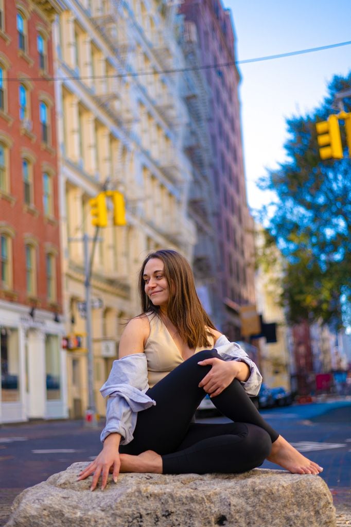 Mujer haciendo yoga al aire libre, en una gran ciudad