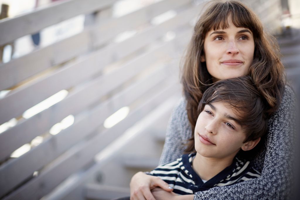Madre abrazando a su hijo adolescente