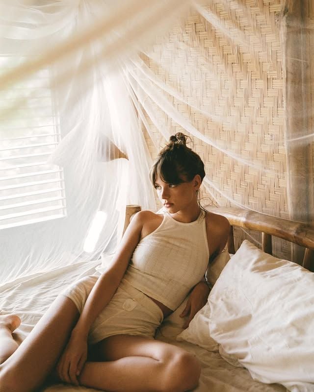 Mujer con conjunto de Miyako Official en una cama con dosel