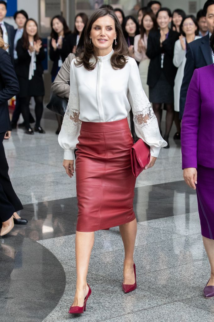 La reina Letizia en Seúl con falda de cuero burdeos de Hugo Boss