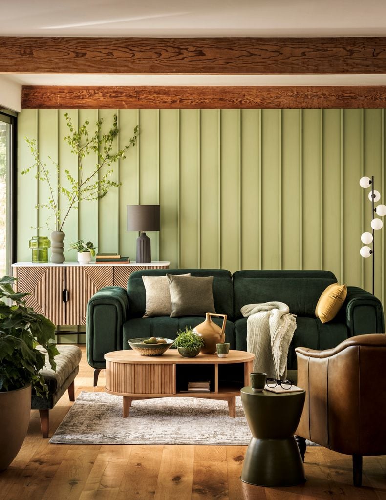 Salón con sofá verde, pufs  y sillón de cuero