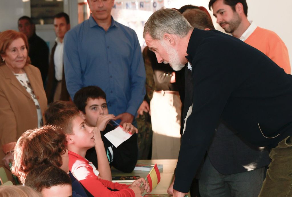 Plano medio del rey Felipe conversando con algunos alumnos del colegio