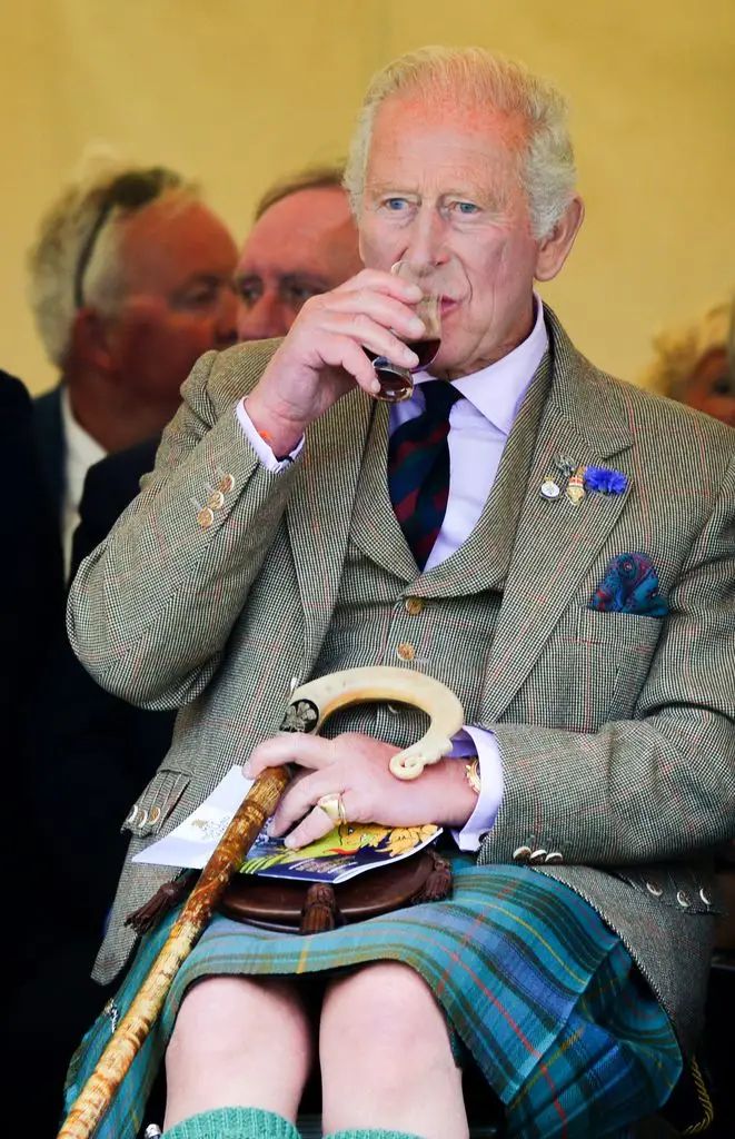 El rey Carlos III, ataviado con el traje tradicional de las Tierras Altas, disfruta de un trago durante los Juegos de las Tierras Altas de Mey 2026.