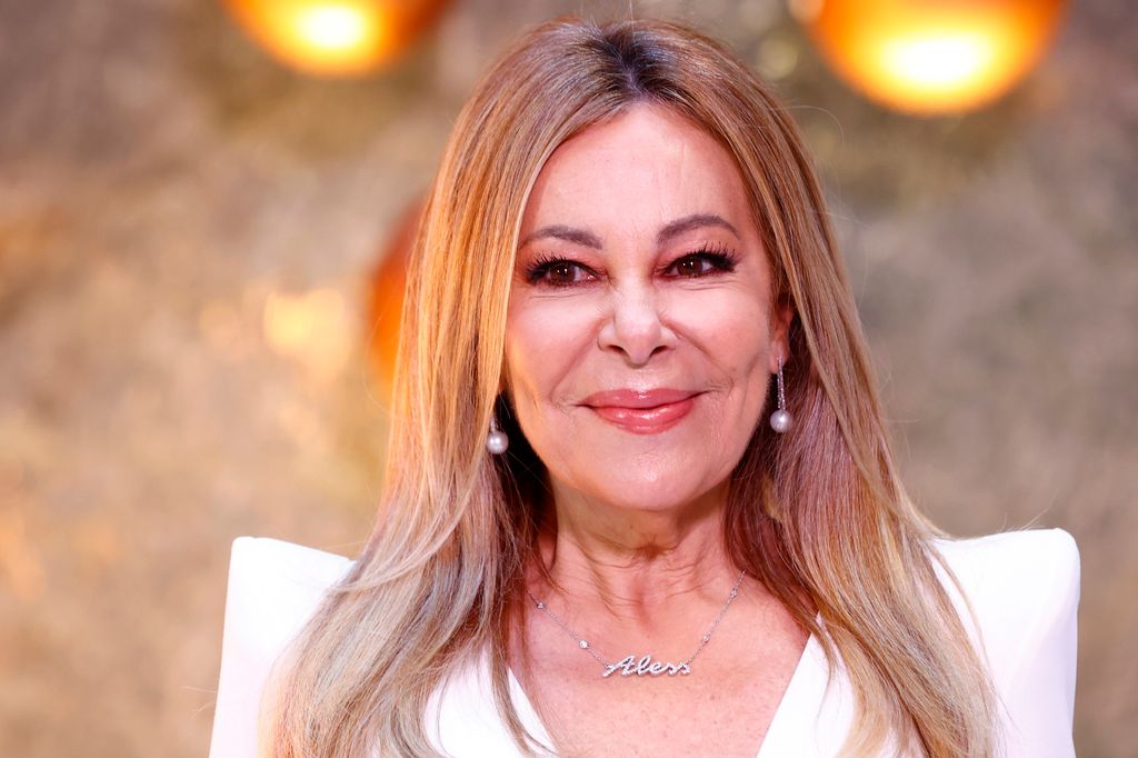Ana Obregón sonríe con un vestido blanco y aretes de perlas.