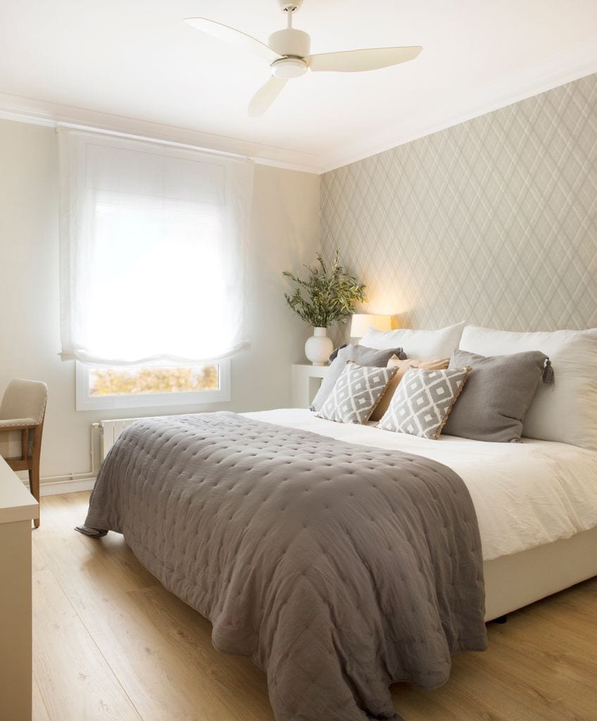 Dormitorio con papel pintado en pared del cabecero