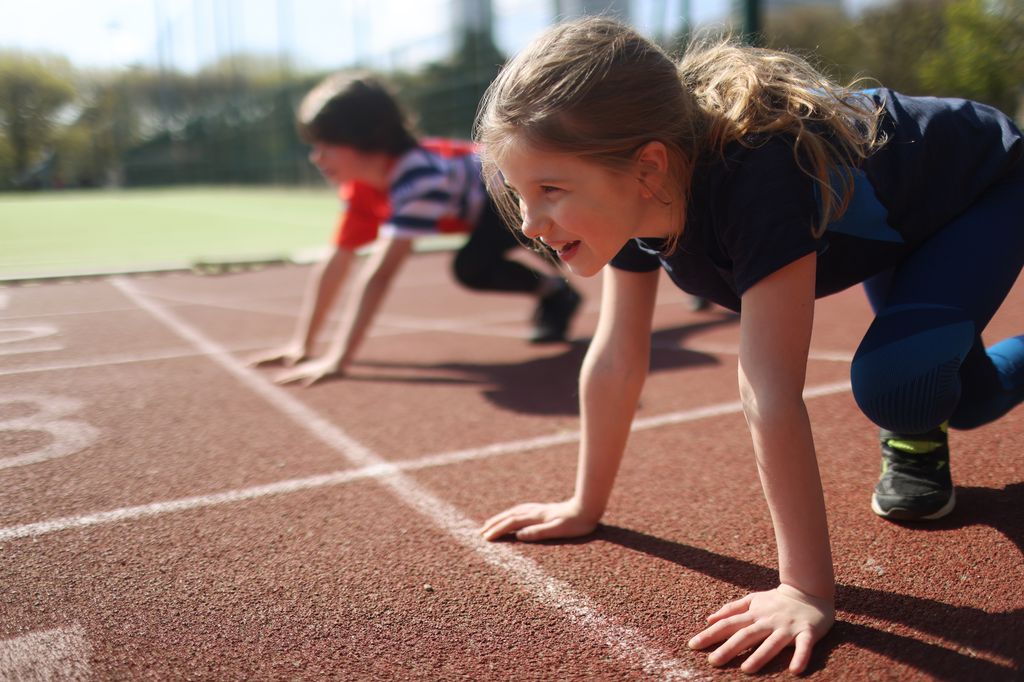 Niños haciendo atletismo en una pista