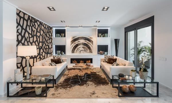 En el salón los sofás, colocados simétricamente, contribuyen a enmarcar un espacio presidido por un mueble a medida lacado en blanco, en el que adquiere especial protagonismo la chimenea de bioetanol.
© Estudio de interiorismo Laura Yerpes
