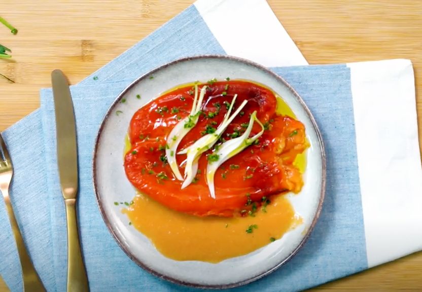 Ensalada de pimientos asados con salsa de tomate y cebolleta.