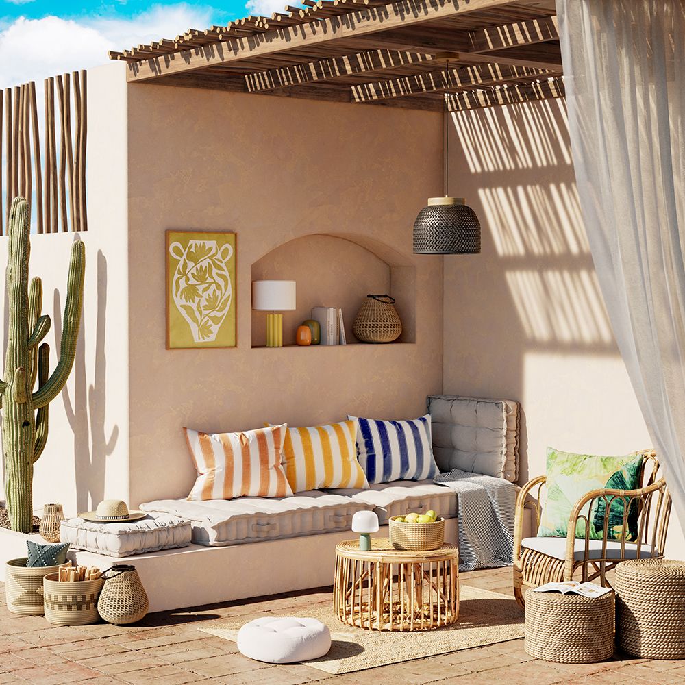 Rincón chill out con banco de obra, muebles de ratán y cojines a rayas