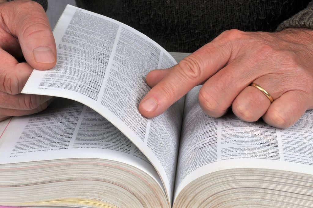 Hombre buscando palabras en un diccionario