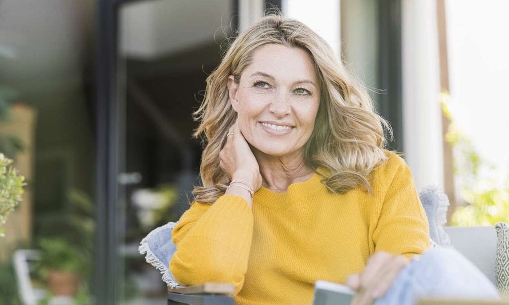Mujer en la menopausia relajada en una terraza