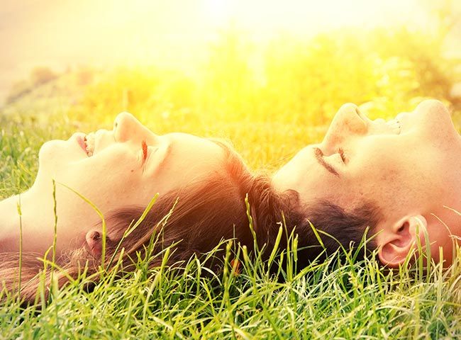 jóvenes tumbados al sol sonriendo