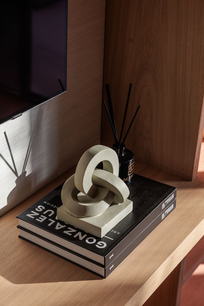 Escultura y difusor de varillas sobre pila de libros