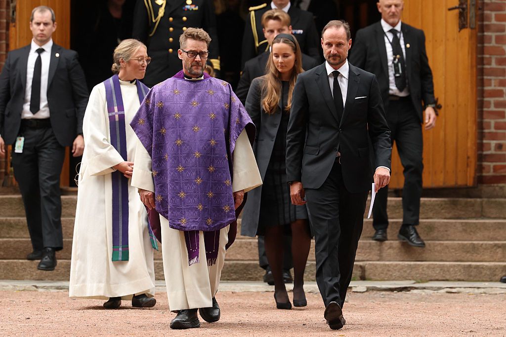 El rey Haakon, la princesa heredera Ingrid Alexandra y el príncipe Sverre Magnus, acompañados por el decano y la párroca salen de la iglesia de Asker tras asistir a un servicio religioso conmemorativo por el difunto rey Harald