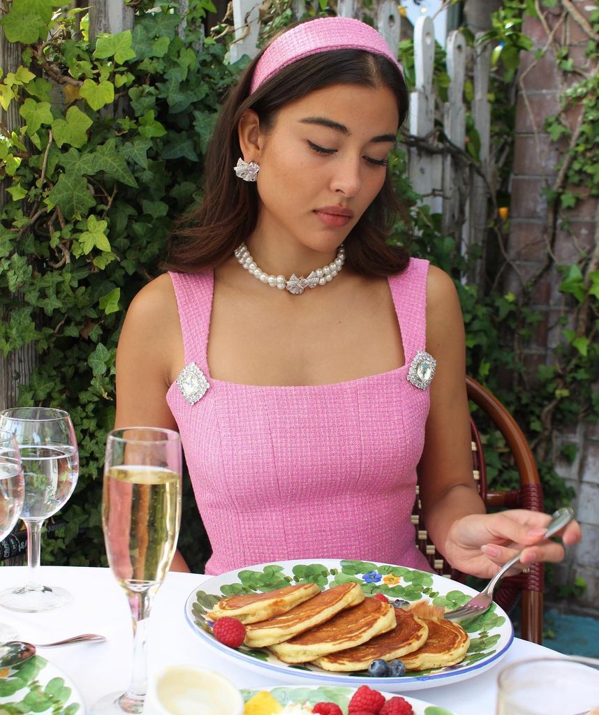Modelo con look rosa comiendo unas tortitas 