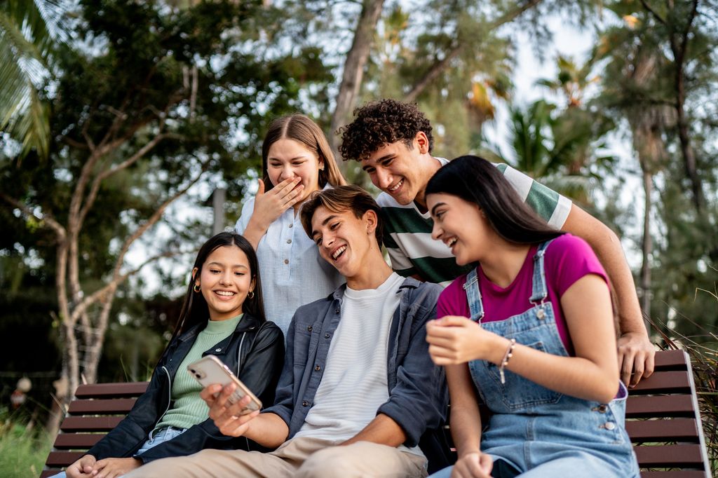 Grupo de adolescentes riendo juntos en un parque