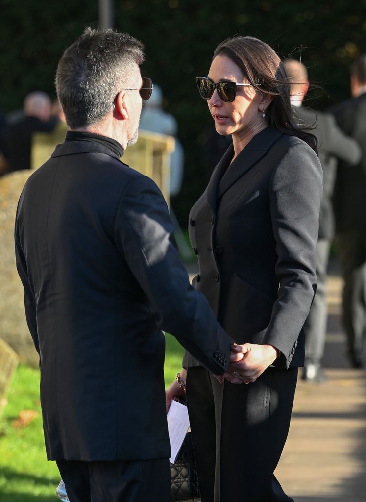 Plano medio de Simon Cowell y Lauren Silverman en el funeral de Liam Payne