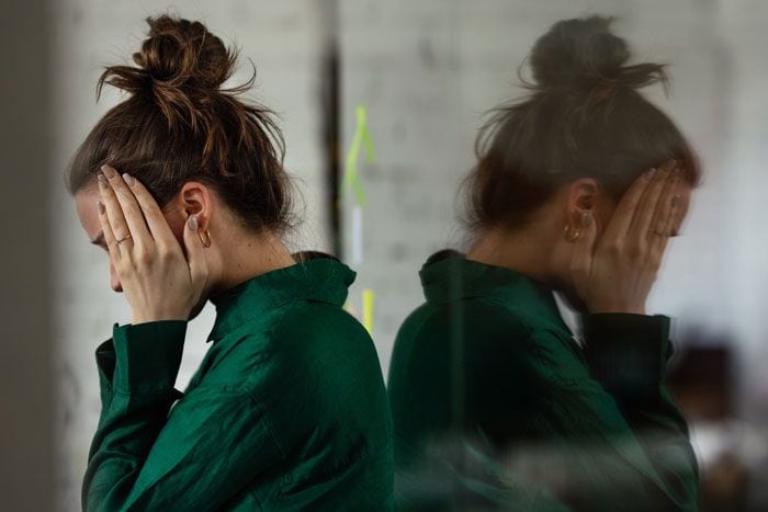 mujer tapándose la cara con las manos