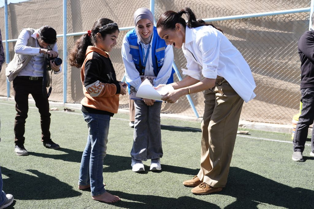 Meghan Markle atiende a una pequeña, quien al parecer le entregó un dibujo. La duquesa escucha con atención a la niña. 
