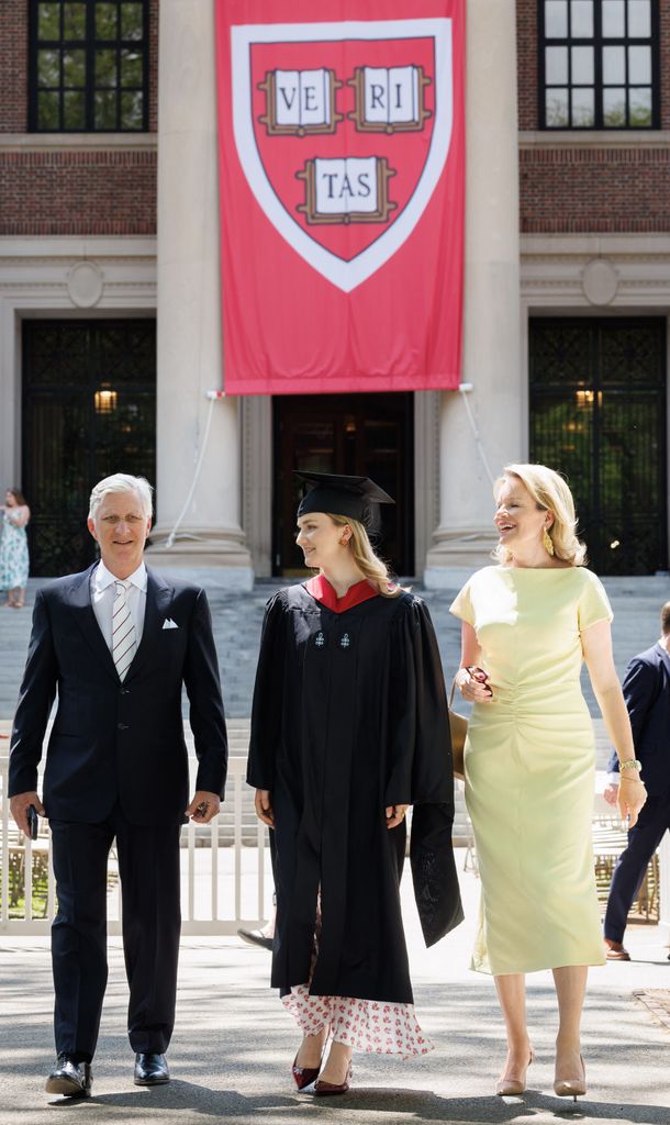 Elisabeth de los belgas, ya graduada, flanqueada por sus padres