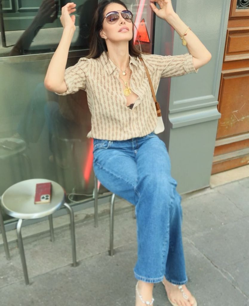 Adriana Abascal, con vaqueros, camisa de manga larga y sandalias en verano.