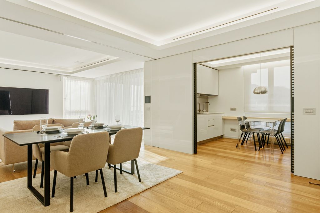 Un salón comedor abierto a la cocina de estética bonita pero impersonal  