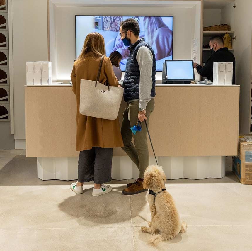 Una pareja en una tienda de muebles acompañados de su perro