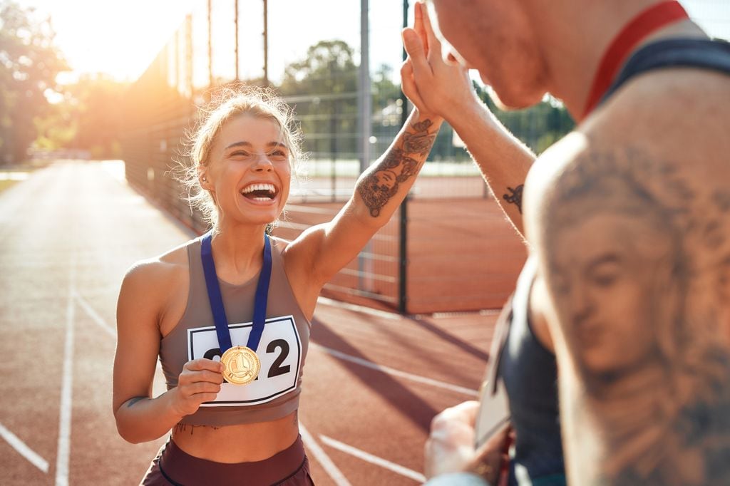 atletas celebrando la medalla en la pista de atletismo