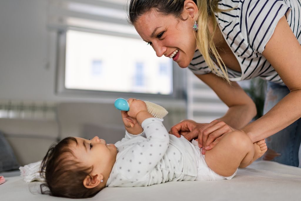 Madre aseando a su bebé en el cambiador
