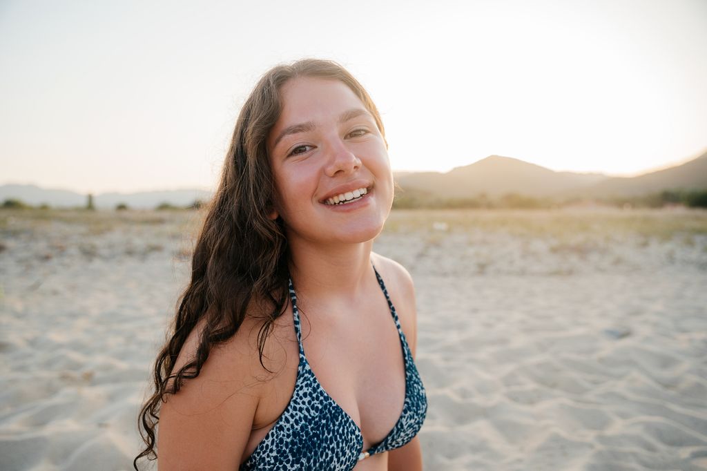 Adolescente en una playa al atardecer