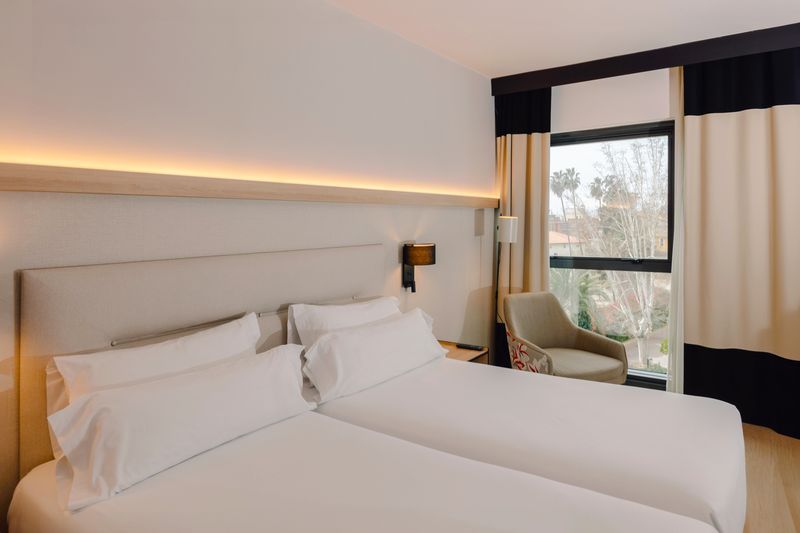 Dormitorio con dos camas y cabecero retrolimuninado