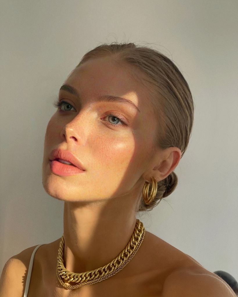 Primer plano mujer rubia con piel luminosa y joyas doradas