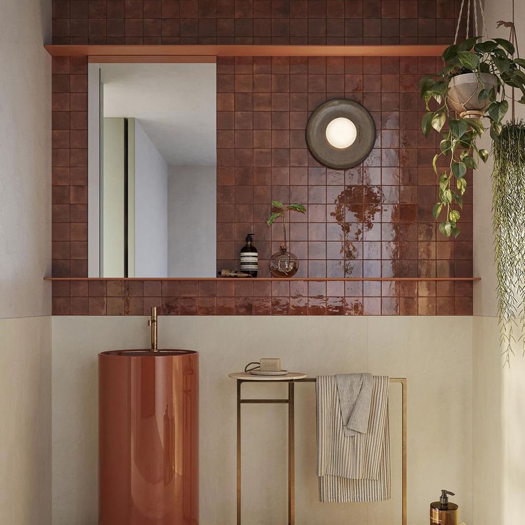Baño con azulejos marrones. 