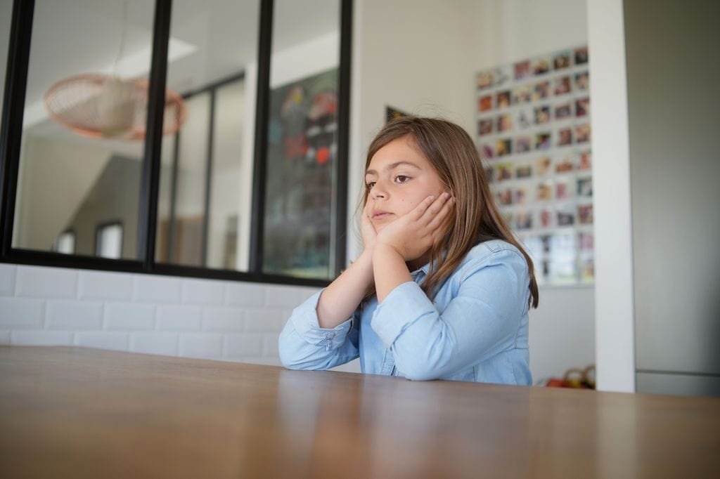 Niña de 10 años triste mirando al frente