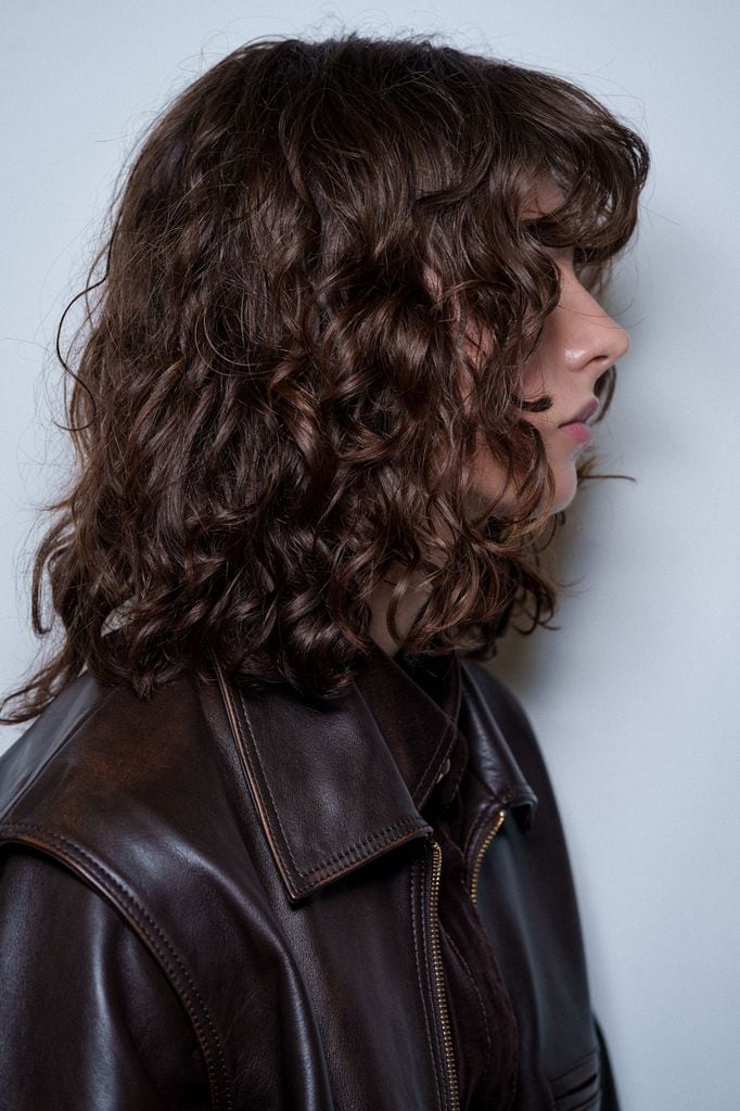 Modelo en el backstage del desfile de Aje con pelo rizado y chupa de cuero