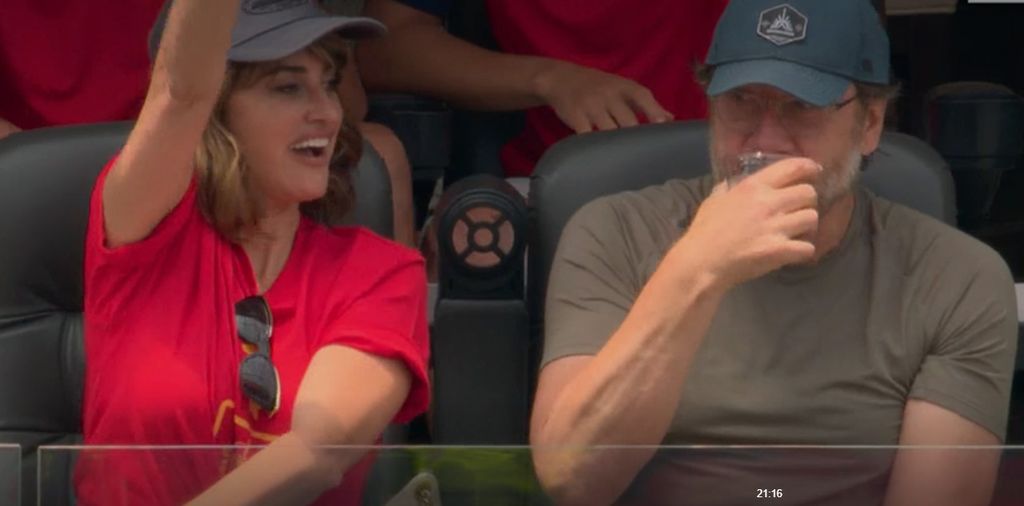 Javier Bardem tomando algo mientras Penélope Cruz saluda