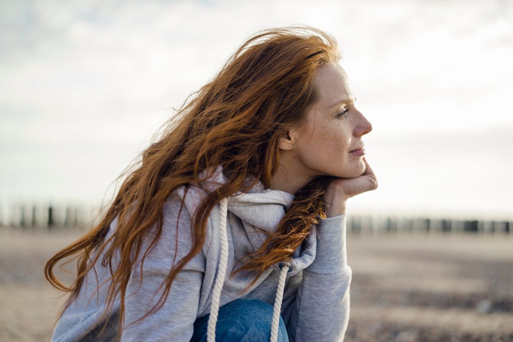 Mujer de 30 años pensativa mirando al horizonte