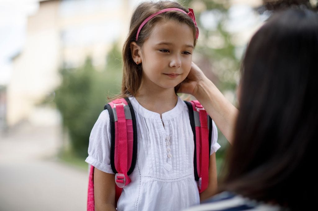 Madre apoya a su hija antes de entrar en el colegio