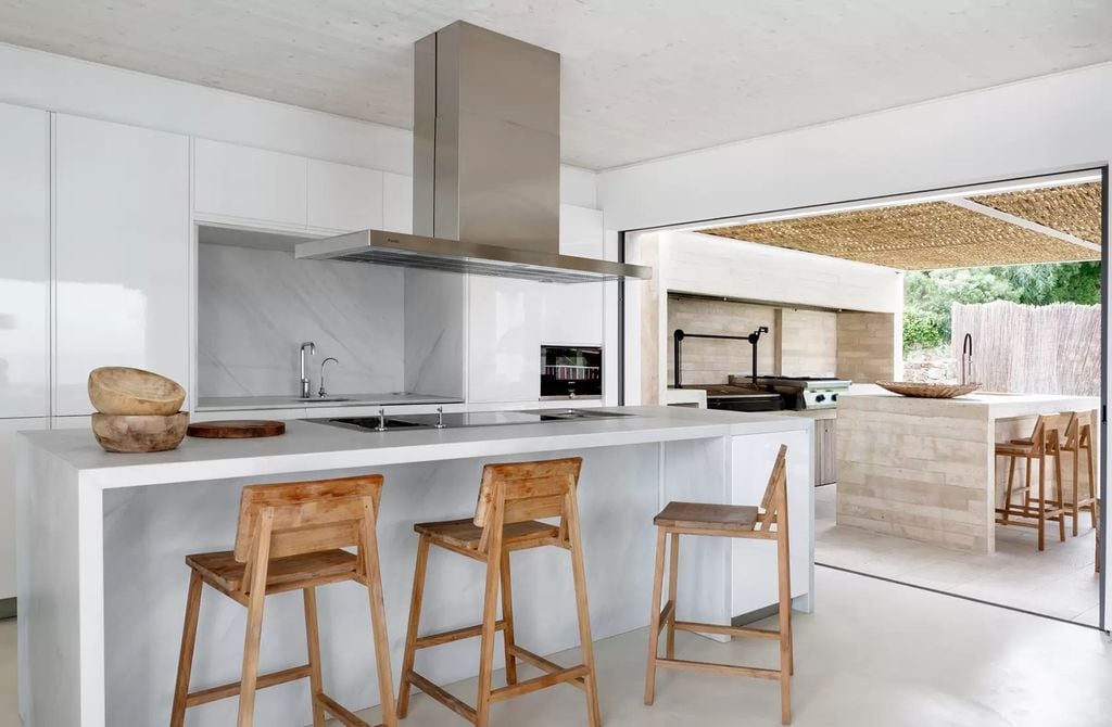 Cocina en una casa en Menorca con isla que alberga la zona de fuegos