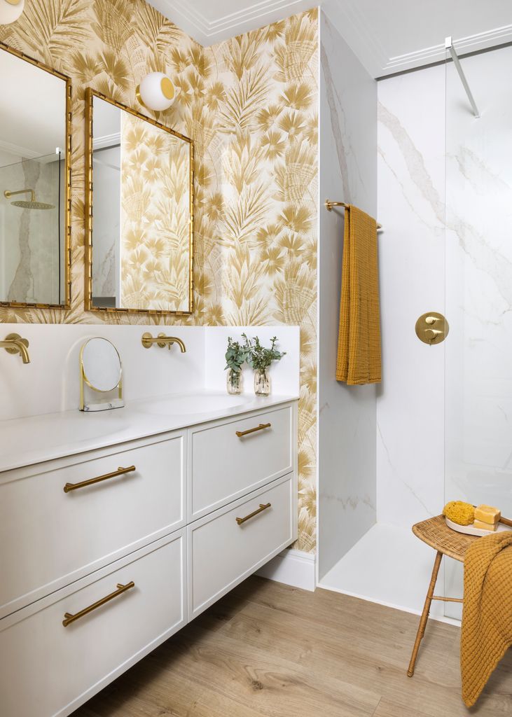 Cuarto de baño con mueble blanco y papel pintado ocre