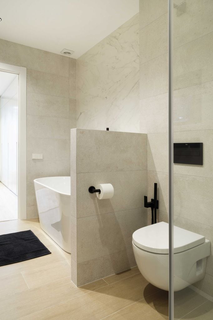 Baño con inodoro con cisterna empotrada.