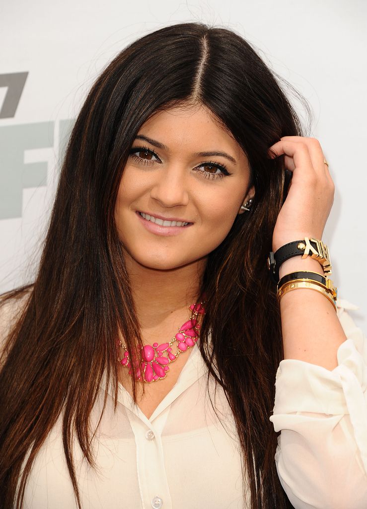 Kylie Jenner en 2012 con el pelo suelto, collar rosa fosforito y camisa blanca