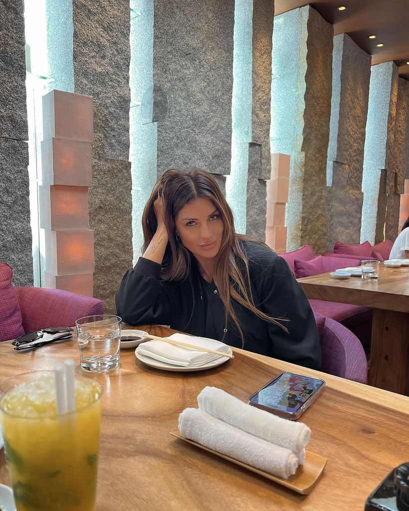 Primer plano de Magali Aravena en un restaurante con chaqueta negra